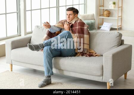 Man setting air conditioner to heat at home. Concept of heating season Stock Photo