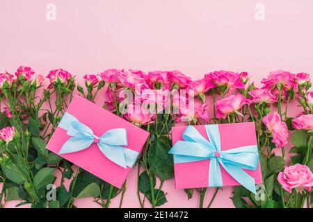 Floral concept made of pink roses flowers and gifts on pink background. Flat lay, Top view. Stock Photo