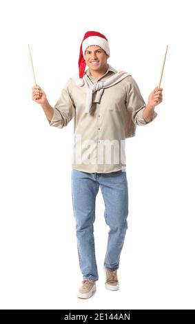 Young man in Santa hat and with drumsticks on white background Stock Photo