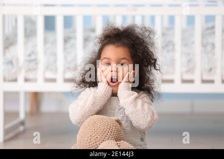 Shocked African-American baby girl at home Stock Photo