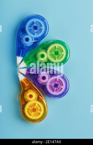 Stationery correction tapes are Multicolored on a blue background. Free space. The view from the top. Blue, green, yellow, lilac Stock Photo