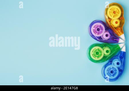 Stationery correction tapes are Multicolored on a blue background. Free space. The view from the top. Blue, green, yellow, lilac Stock Photo