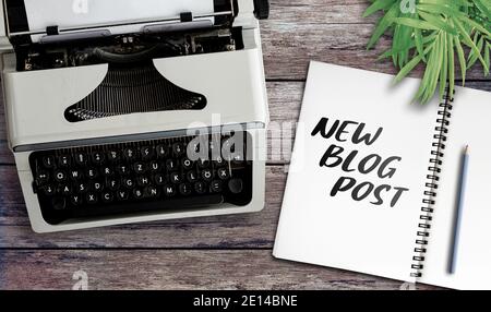 text NEW BLOG POST on notepad on table with old typewriter, blogging concept Stock Photo