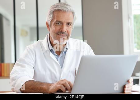 Portrait of attractive mature doctor working in office Stock Photo