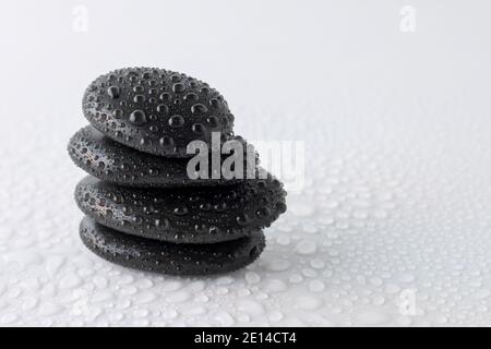 stacked black stones on white background Stock Photo