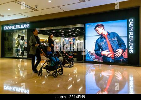 Shanghai,  CHINA, Contemporary Interiors, Shopping Center,  HKRI Taikoo Hui, People, American Advertising Poster, Calvin Klein, contemporary retail interior design, Prestige consumer Shop Fronts, china capitalism Women with Children Walking in Front, china luxury shopping mall [WP] Stock Photo