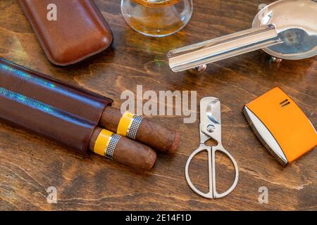 Tobacco and alcohol. Cigar and brandy on a wooden table, top view. Cuban quality brand cigars and rum, smoking and drinking luxury lifestyle Stock Photo