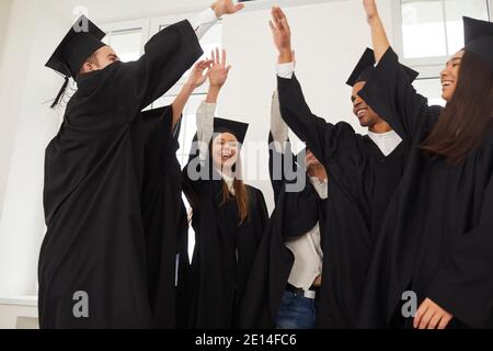 Graduates raise hands, which they stacked on top of each other in a sign of completion of training. Stock Photo