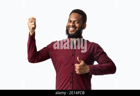 Cheerful African Guy Gesturing Thumbs-Up Approving Taste Over White Background Stock Photo