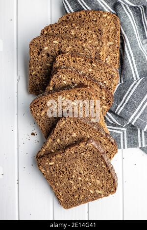 Dieting cereal bread with sunflower seeds on white table. Top view. Stock Photo