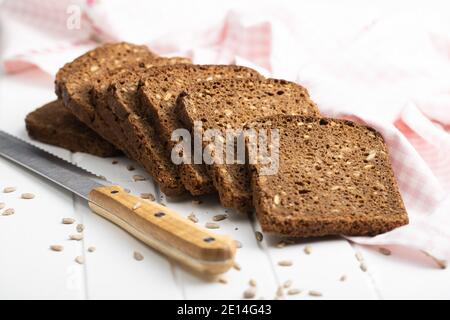 Dieting cereal bread with sunflower seeds on white table. Stock Photo