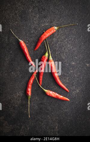 Red chili peppers on black table. Top view. Stock Photo