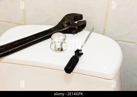 Cistern for flushing water on the toilet and a set of tools for repairing the cistern. Stock Photo