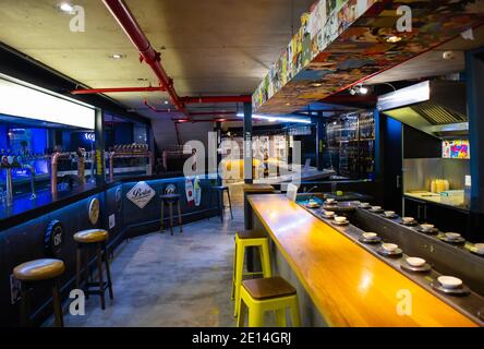 Mojo Market- Cape Town, South Africa - 16/12/2020 Bar lane in Mojo Market. Creative set up and colorful décor. Sushi bar and beer taps in foreground. Stock Photo