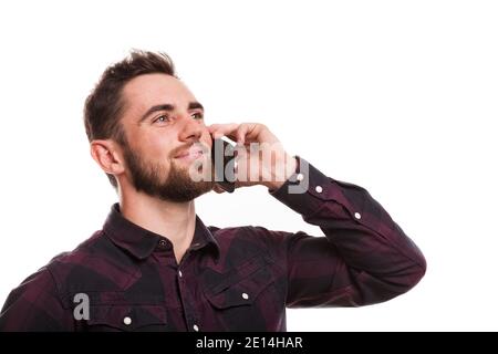 Close up portrait of a handsome bearded man talking on the phone, looking away happily, isolated. Attractive man smiling, calling using his smart phon Stock Photo
