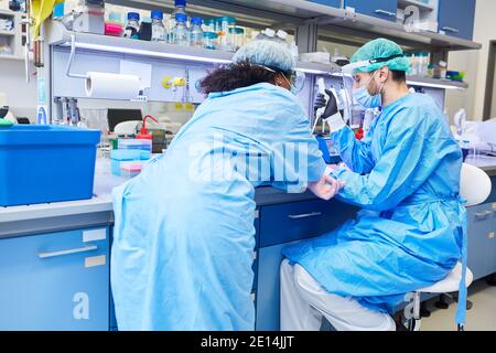 Two researchers in the laboratory working together on Covid-19 vaccine in the coronavirus pandemic Stock Photo