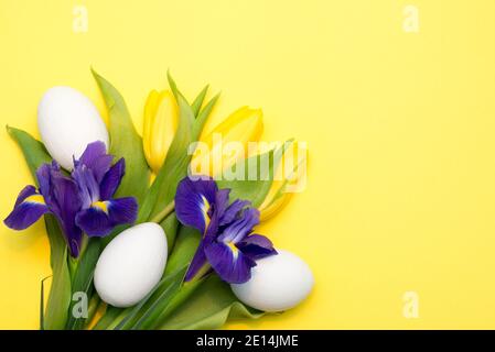 Bright yellow background with spring Easter flowers and eggs with a copy space Stock Photo