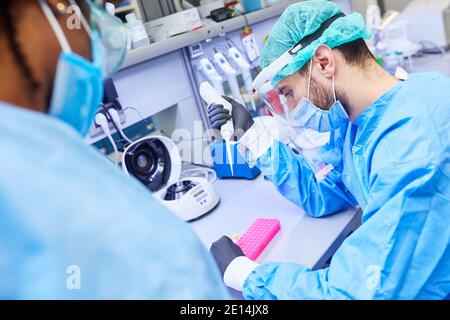 Two biotechnology researchers work together in the laboratory on Covid-19 vaccine for coronavirus pandemic Stock Photo