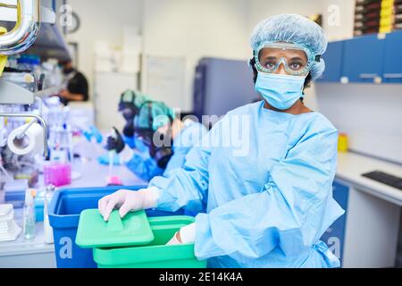 Research team with woman works in laboratory on Covid-19 vaccine in coronavirus pandemic Stock Photo
