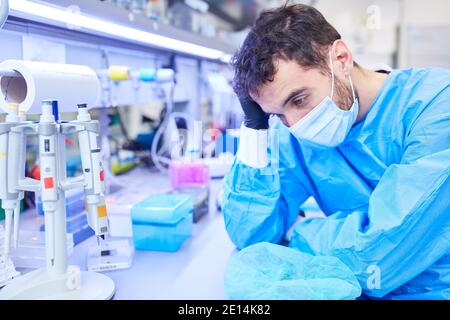 Exhausted doctor has to decide on triage in the intensive care unit of a clinic in the case of Covid-19 and coronavirus pandemic Stock Photo