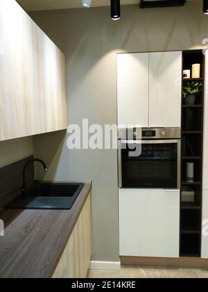 Coordinated minimalistic design of kitchen, tables and worktops Stock Photo