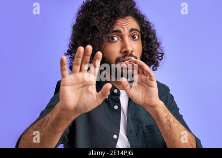 male is panicking. young arab man is terrified with fear expression stop gesture with hands, in shock. panic concept. Stock Photo