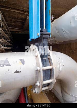 Stainless steel sludge pipe with Knife gate valve remotely controlled by servo drive engine and thick-walled flanges. Stock Photo