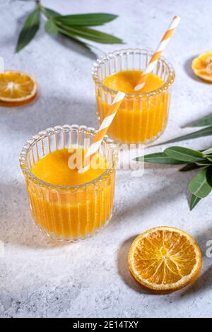 Fresh made orange juice beautifully arranged in two glasses on a marble table, top view, portrait, Stock Photo