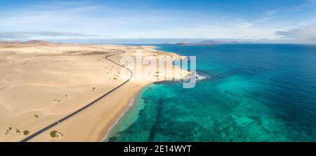 Aerial panoramic coastal view of a road passing through the sandy Corralejo Natural Park, Fuerteventura, Canary Islands, Spain