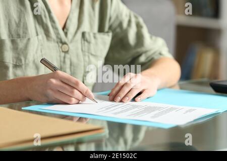 Close up of a woman hands signing contract on a glass table at home Stock Photo