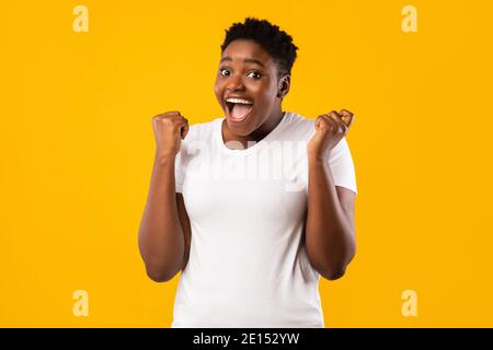 Joyful African American Plus-Size Woman Gesturing Yes Over Yellow Background Stock Photo