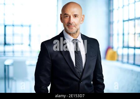 Portrait shot of executive businessman wearing eyewear and suit while standing in the office. Stock Photo
