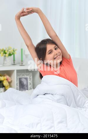 Cute little girl waking up in bed Stock Photo