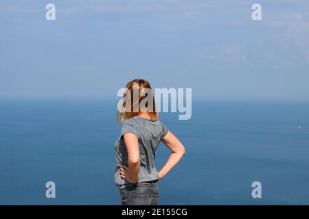 Woman Looking Out at the Sea View on the Isle of Portland, Dorset Stock Photo