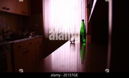 Green Bottle In The Kitchen - Alcohol Abuse Stock Photo