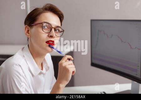 Close up of a beautiful female software developer looking to the camera, working at her office Stock Photo