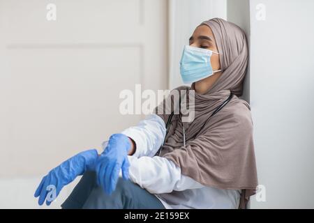 Muslim woman doctor feeling exhausted, working during pandemic Stock Photo
