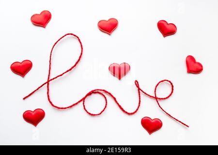 Valentine's day concept. Red heart and word love made from woolen rope on white background Stock Photo