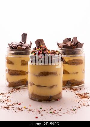 Tiramisu is a coffee-flavored Italian dessert. Tiramisu dessert in jar with chocolate topping and white background Stock Photo