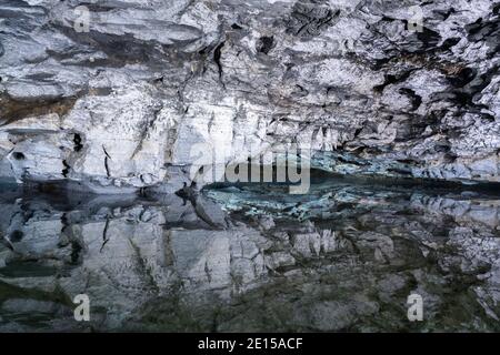 Underground Lake Inside the Ice Cave. Slope of the mountain with the reflection in the water inside a fantastic cave. Kungur In The Urals, Russia Stock Photo