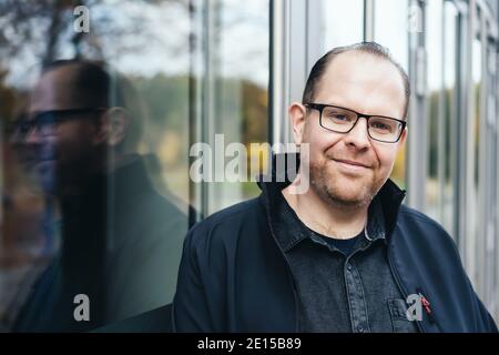 portrait picture of a young man leaning against windows Stock Photo