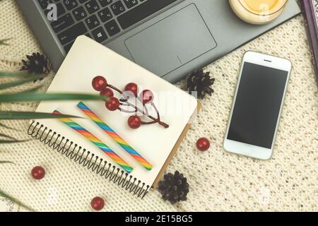 Flat lay composition, winter cozy background with food, candy, smartphone and decorations, workplace or workspace at holiday photo Stock Photo