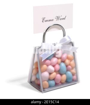 A small purse-shaped place card holder party favor filled with Jordan almonds photographed on a white background Stock Photo