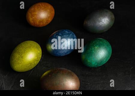 colorfull marble painted easter eggs on black background. Concept of minimal festive Easter backdrop. Stock Photo