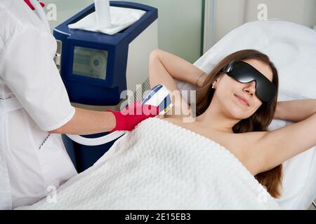Woman at the spa getting laser hair removal on armpit Stock Photo