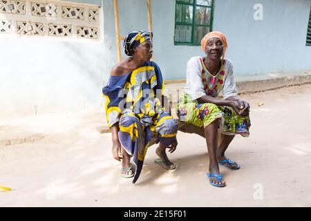 Two Gambian ladies sitting on a bench in the village of N'Demban in the Gambia, West Africa Stock Photo