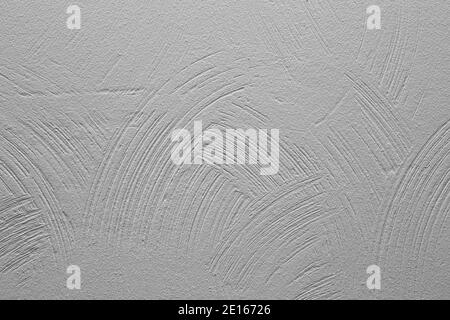 Decorative plaster. Wall with rounded stripes of applied plaster, painted in gray. Background for text. Stock Photo
