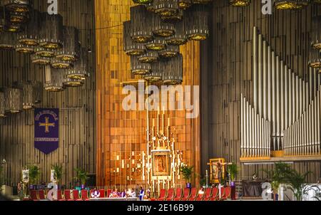 Church Service, with painting of the Guadalupe Hanging above alter, Shrine of the Guadalupe, Mexico City Stock Photo