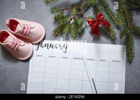 Baby's shoes, winter calendar for January. The announcement of the pregnancy Stock Photo