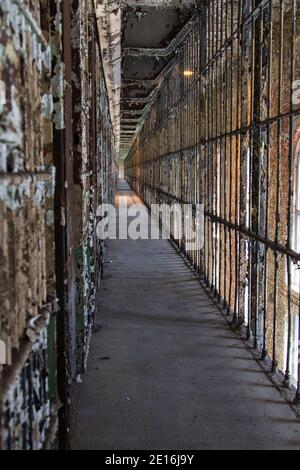 Abandoned Prison Interior. Row of empty cells on cell block of abandoned prison in vertical orientation. Stock Photo